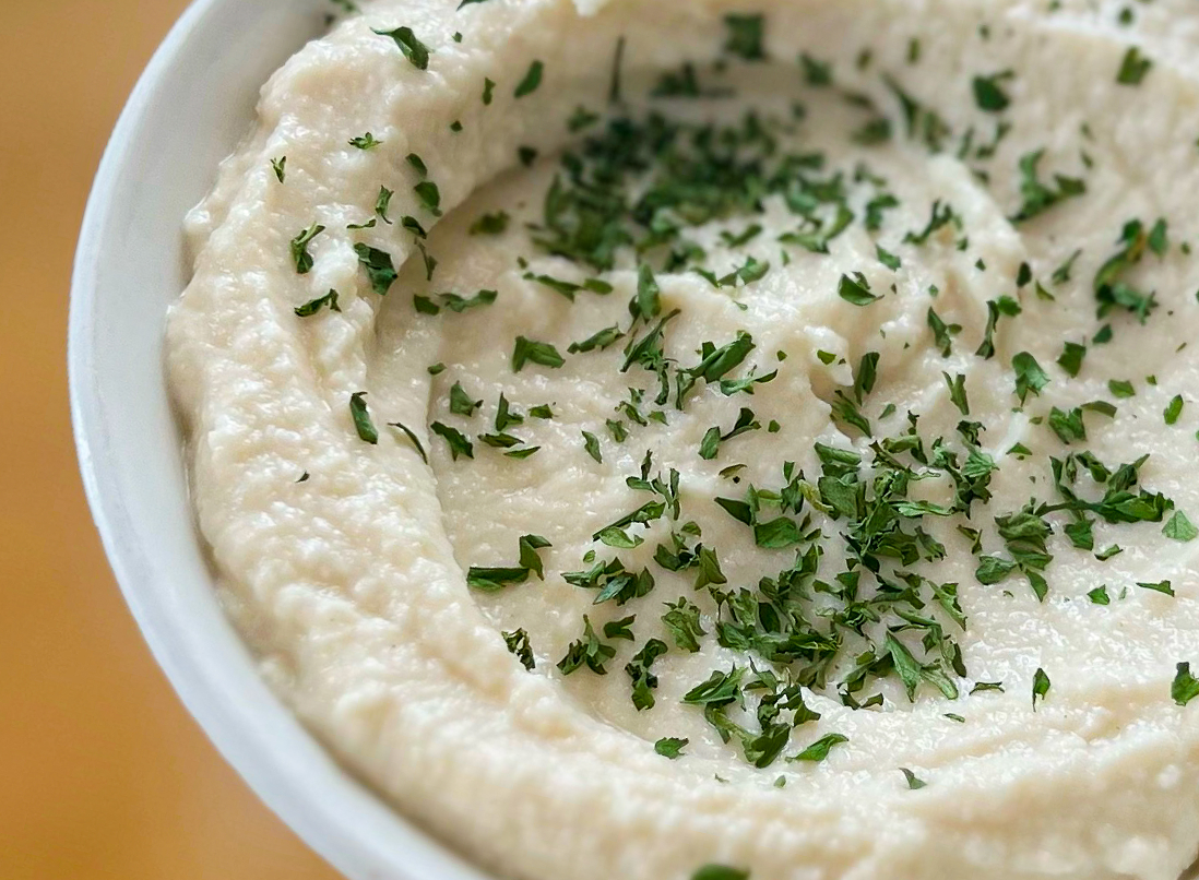 Roasted Cauliflower Hummus with Fresh parsley in a bowl