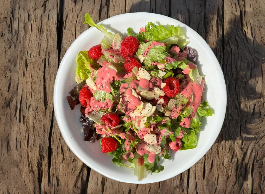 Raspberry-Sumac Vinaigrette with fresh raspberries on a fresh green salad.